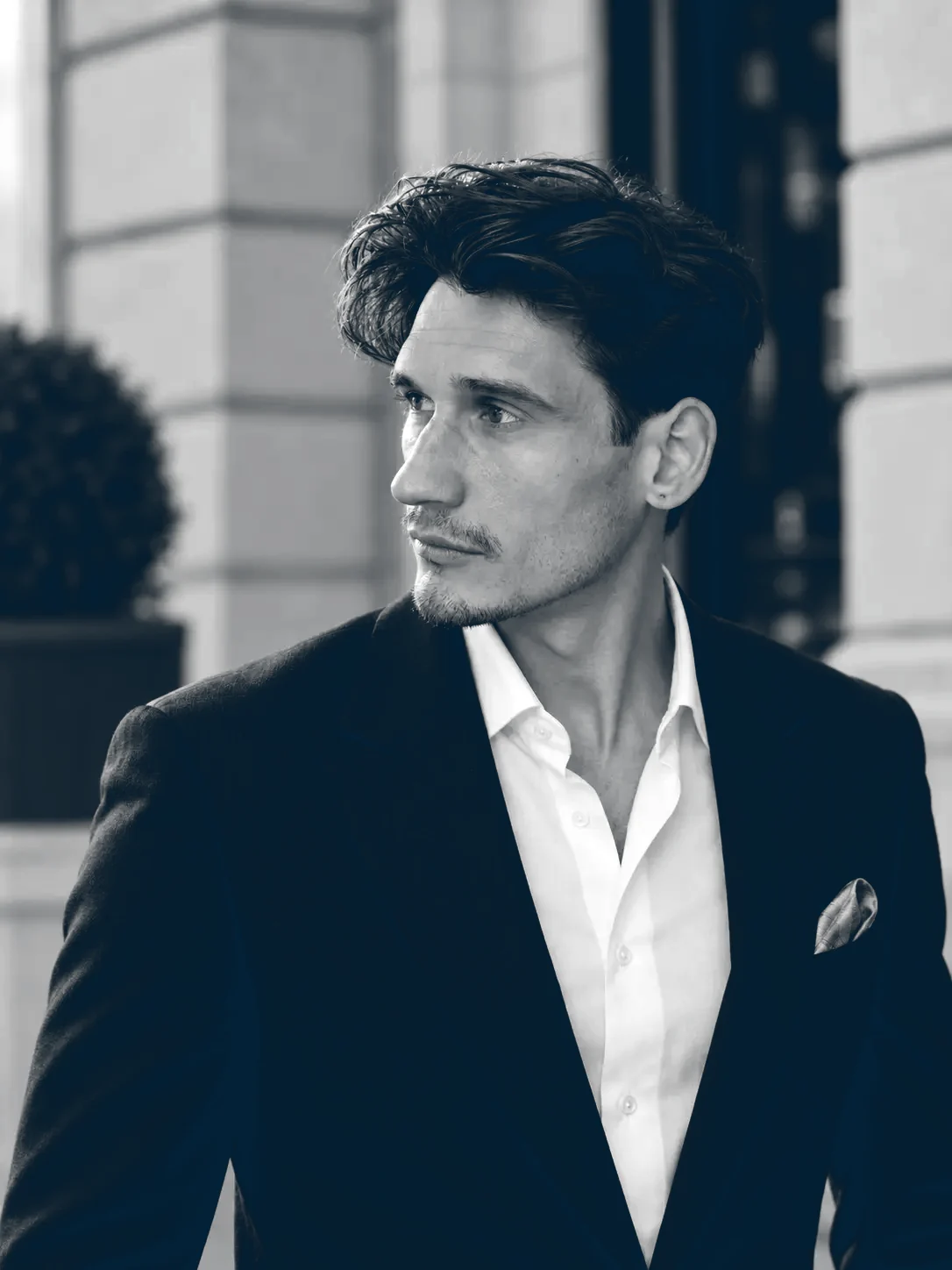 Joshua Cleland, founder of Cleland Studio, in a dark suit and an open-collared white shirt