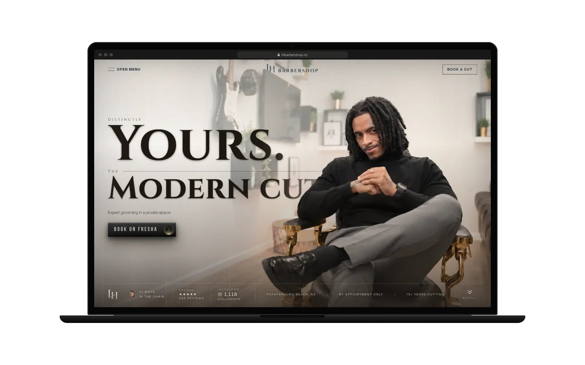 LH Barbershop’s hero on a laptop: Leandro in the barber chair beside “Distinctly Yours. The Modern Cut.” and Book on Fresha